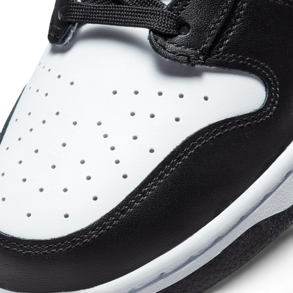 Details the micro-precision of the perforated white leather toe box, showing the double-stitched black toe mudguard and the neat tracking of the black laces.