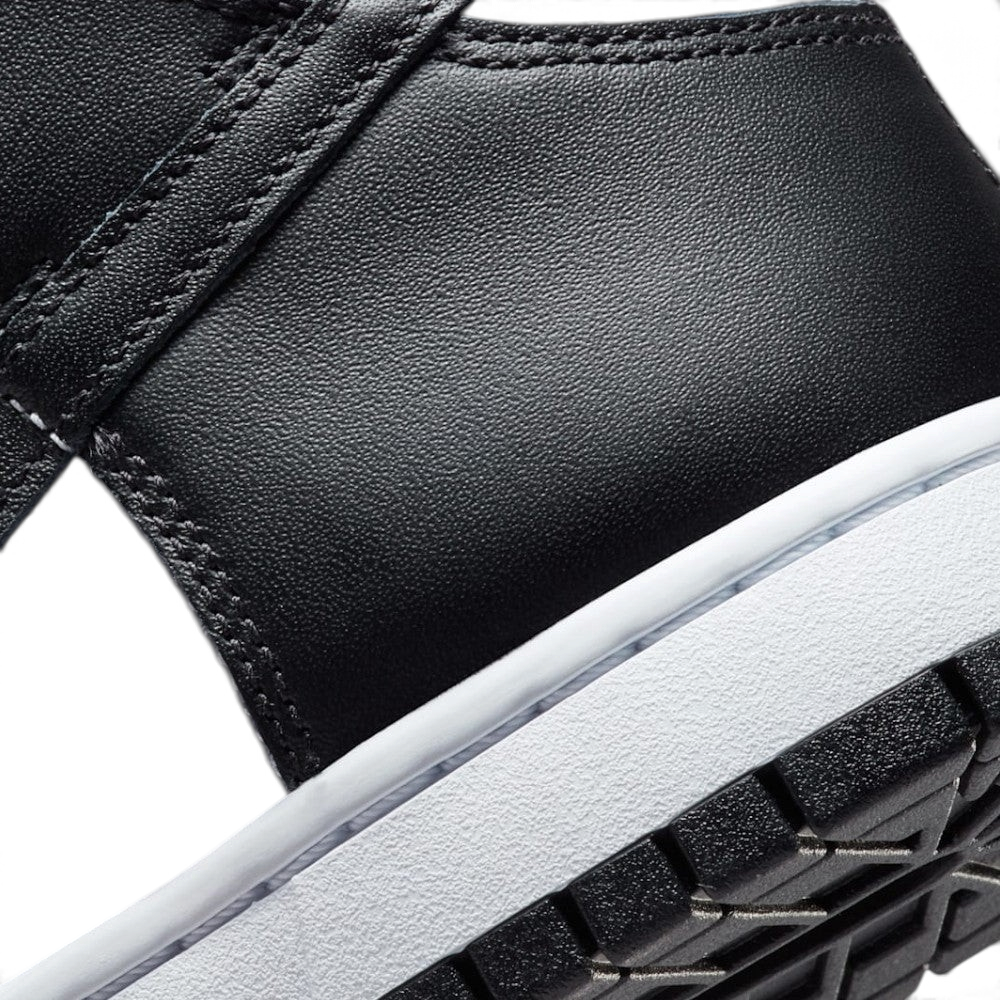 Highlights the "unreal" clean finish where the smooth white rubber midsole meets the textured black leather upper and the durable black pivot-circle rubber tread below.