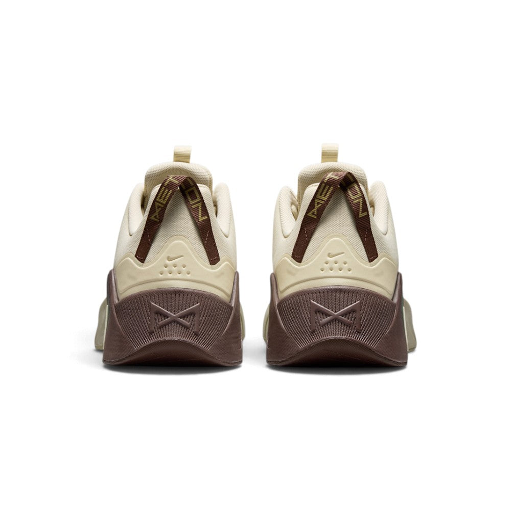 Close-up rear angle focusing on the stable chocolate-brown heel counter with an embossed cross-training graphic, vertical striped pull tabs, and the flared rear stability base.