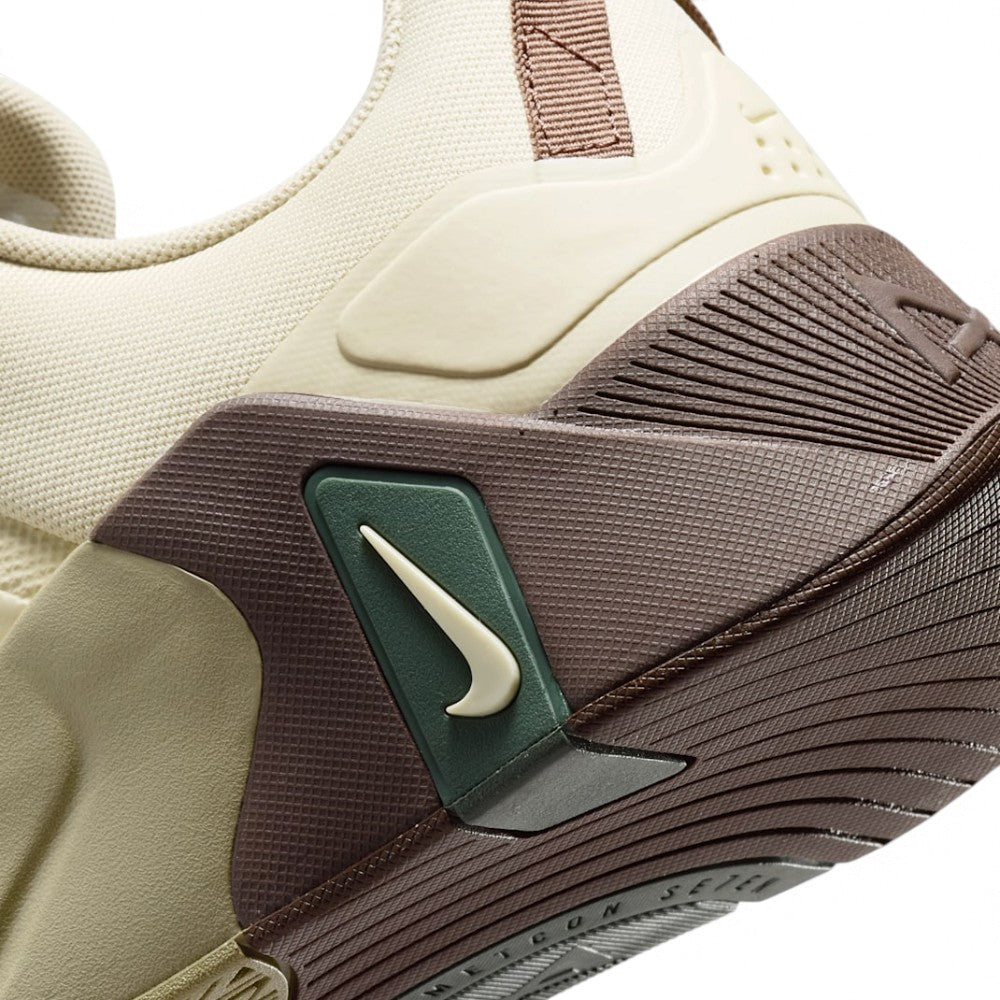 Macro view of the lateral heel transition, highlighting the rich chocolate-brown heel wrap, the embedded olive green Swoosh housing plate, and the seamless sole bonding edge.
