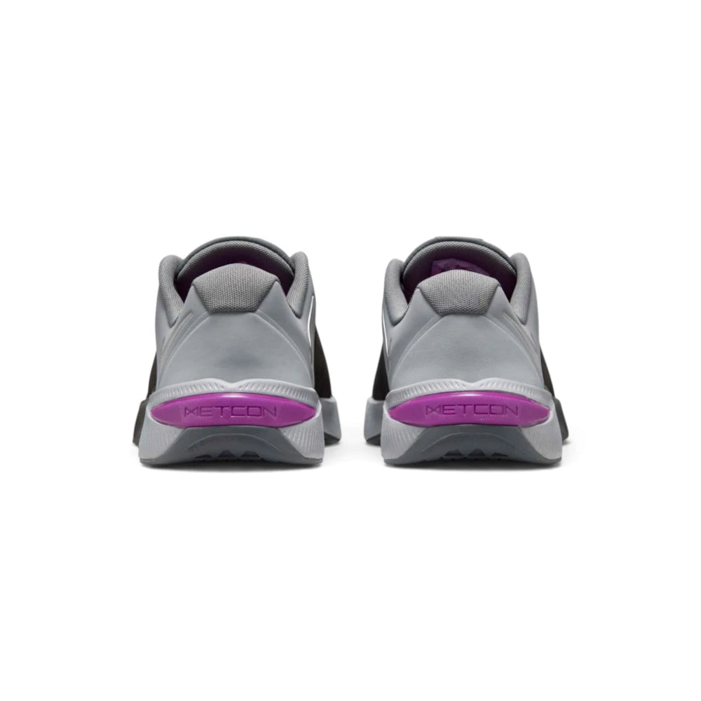 Focuses on the rear profile, highlighting the grey synthetic heel counters, wide flared ReactX foam base, and the prominent Vivid Purple plastic heel clip stamped with debossed "METCON" lettering.