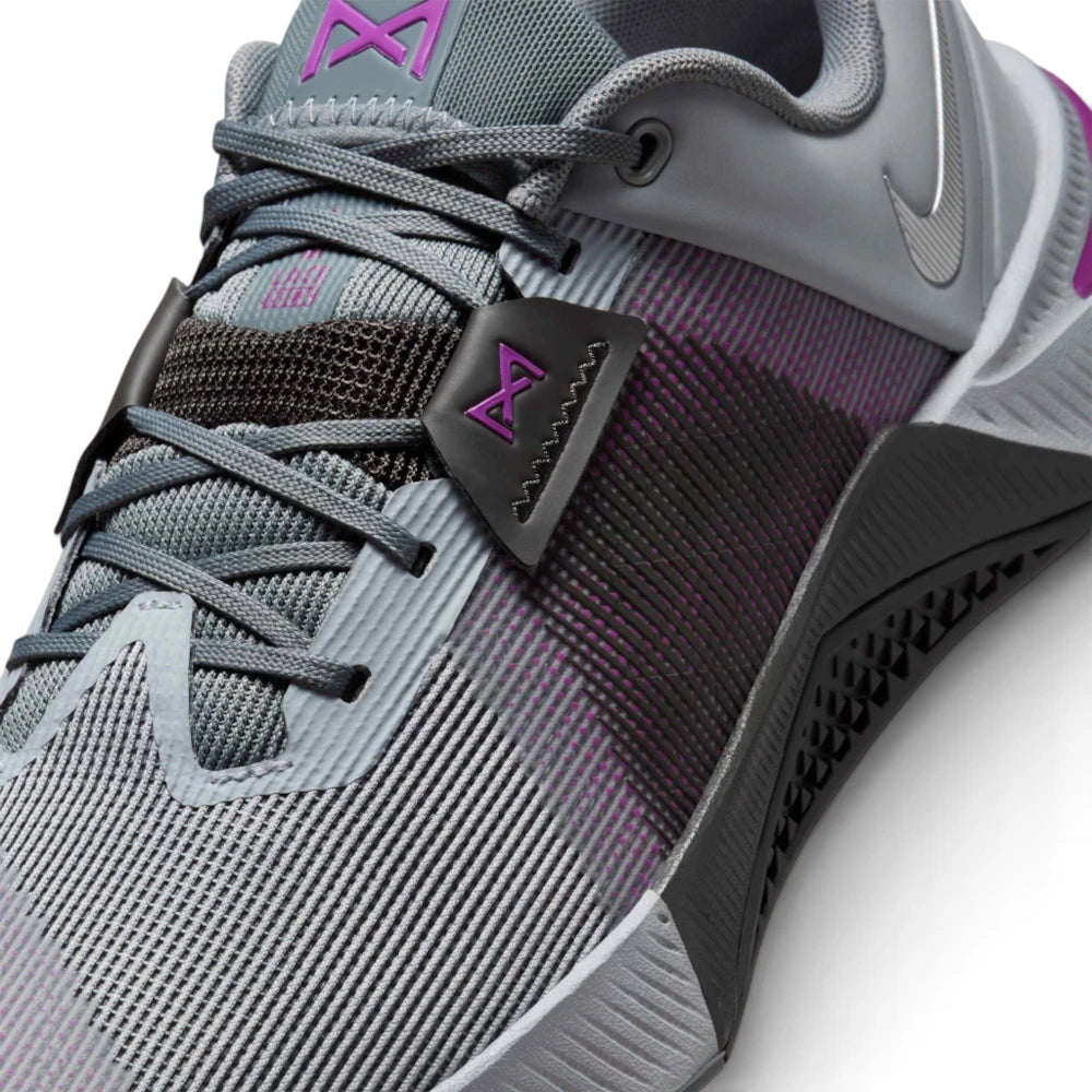 Details the micro-precision of the open-holed mesh upper, showing the reinforced dark toe guard with mini Swoosh, grey laces, black midfoot band with purple emblem, and the textured rubber sidewall wrap.