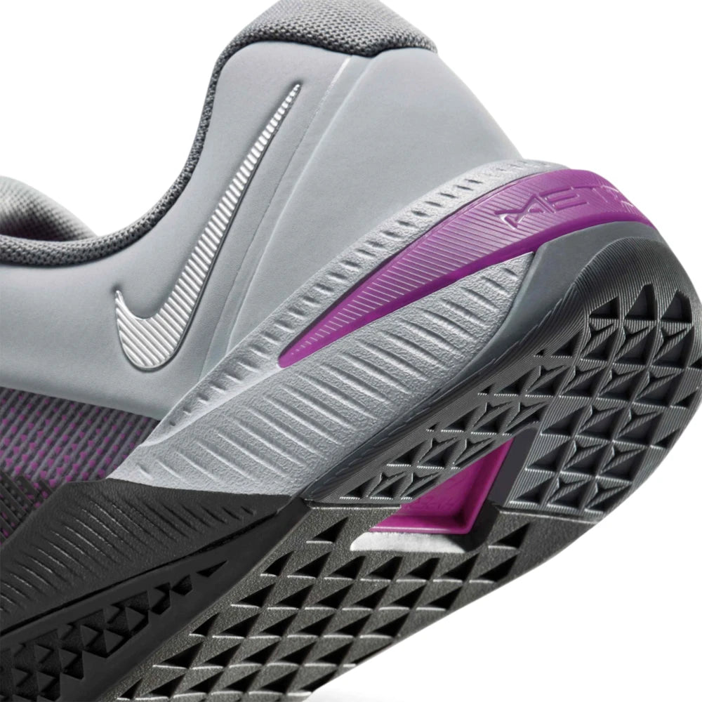 Highlights the "unreal" clean finish where the grooved grey foam midsole carrier meets the triangular rubber outsole tread, framing the metallic silver heel Swoosh and Vivid Purple Hyperlift window.