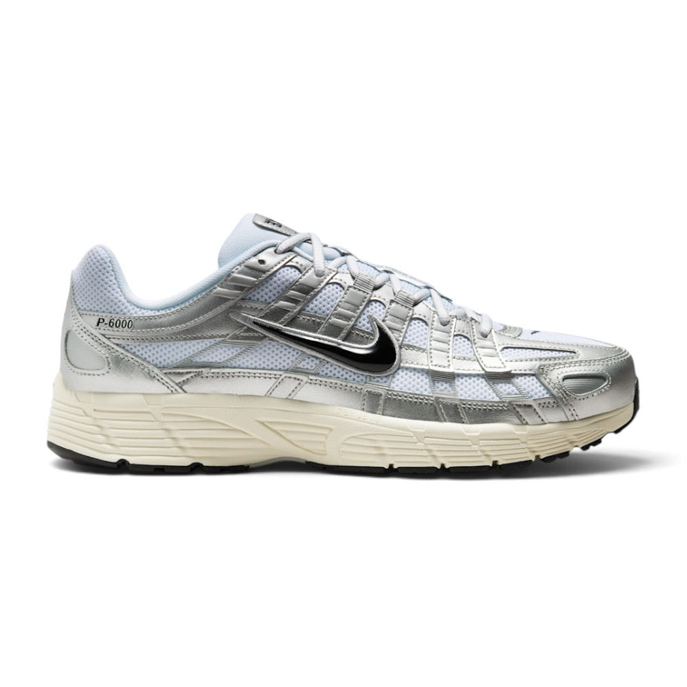 Capturing the 2000s retro running silhouette, detailing the white open-mesh upper, horizontal and vertical metallic silver leather overlays, dimensional moulded black Swoosh, sculpted white foam midsole, and black rubber outsole edge.