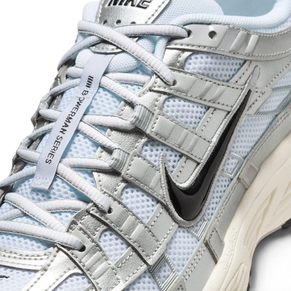 Focusing on the Breathable Open-Hole Mesh Toe Box, High-Shine Metallic Silver Cross-Overlays, and Branded Tongue Webbing, demonstrating the upper airflow channels, structural containment boundaries, and refined finish as the stylish final detail.