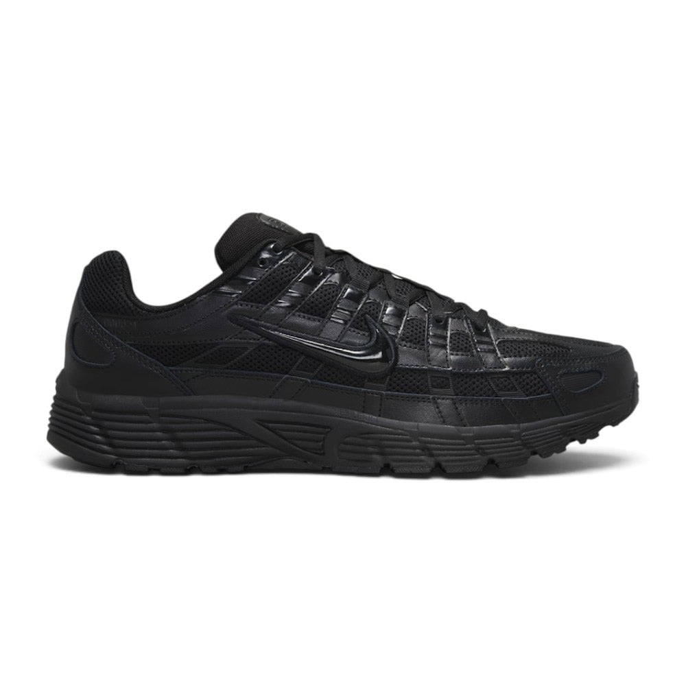 Highlights the early-2000s lateral silhouette featuring the stealth black mesh upper, horizontal and vertical leather lattice overlays, glossy moulded black Nike Swoosh, sculpted black foam midsole, and black rubber outsole. Main image