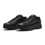 Emphasising the low-slung, technical stance of the trainers and the rich textural interplay between the open mesh panels, smooth leather overlays, and gloss branding hits.