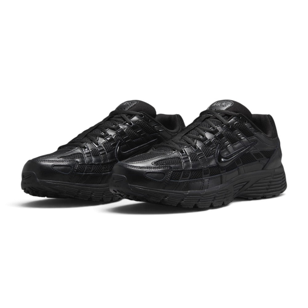 Emphasising the low-slung, technical stance of the trainers and the rich textural interplay between the open mesh panels, smooth leather overlays, and gloss branding hits.