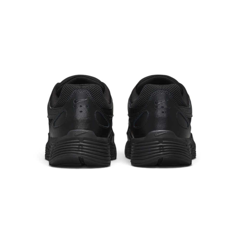 Focuses on the rear profile, displaying the structured black synthetic heel counter, micro-Swooshes, ventilation perforations, and the wide base of the ribbed black foam midsole.