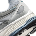 Highlights the "unreal" clean finish of the rear lateral quarter, displaying the embossed "P-6000" collar script, ribbed Sail foam midsole, slate blue wedge insert, and black lugged rubber outsole tread.
