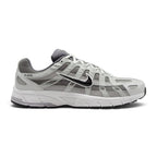 Highlights the early-2000s lateral silhouette featuring the Atmosphere Grey mesh upper, layered Vast Grey and silver leather lattice overlays, moulded synthetic leather Nike Swoosh with black outline, clean foam midsole, and black rubber outsole.