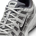 Details the micro-precision of the forefoot area, showing the open-weave Atmosphere Grey mesh toe box, synthetic leather toe cap, flat laces, and central tongue webbing strip.