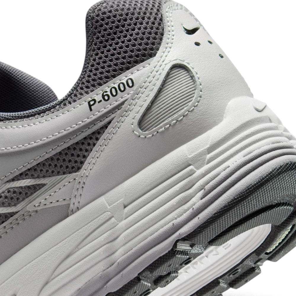 Highlights the "unreal" clean finish of the rear lateral tooling, showcasing the debossed "P-6000" collar script, ribbed foam midsole, and lugged rubber outsole tread.