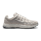 Highlights the early-2000s lateral silhouette featuring the Phantom textile mesh upper, layered Light Bone and Light Smoke Grey leather cage overlays, moulded Nike Swoosh with tonal borders, lifted Sail foam midsole, and dark rubber outsole tread.