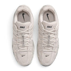 Focuses on the locked-in central lacing layout, displaying flat laces, vertical tongue webbing, padded tongues with Nike logo tabs, cushioned collars, and soft insoles.