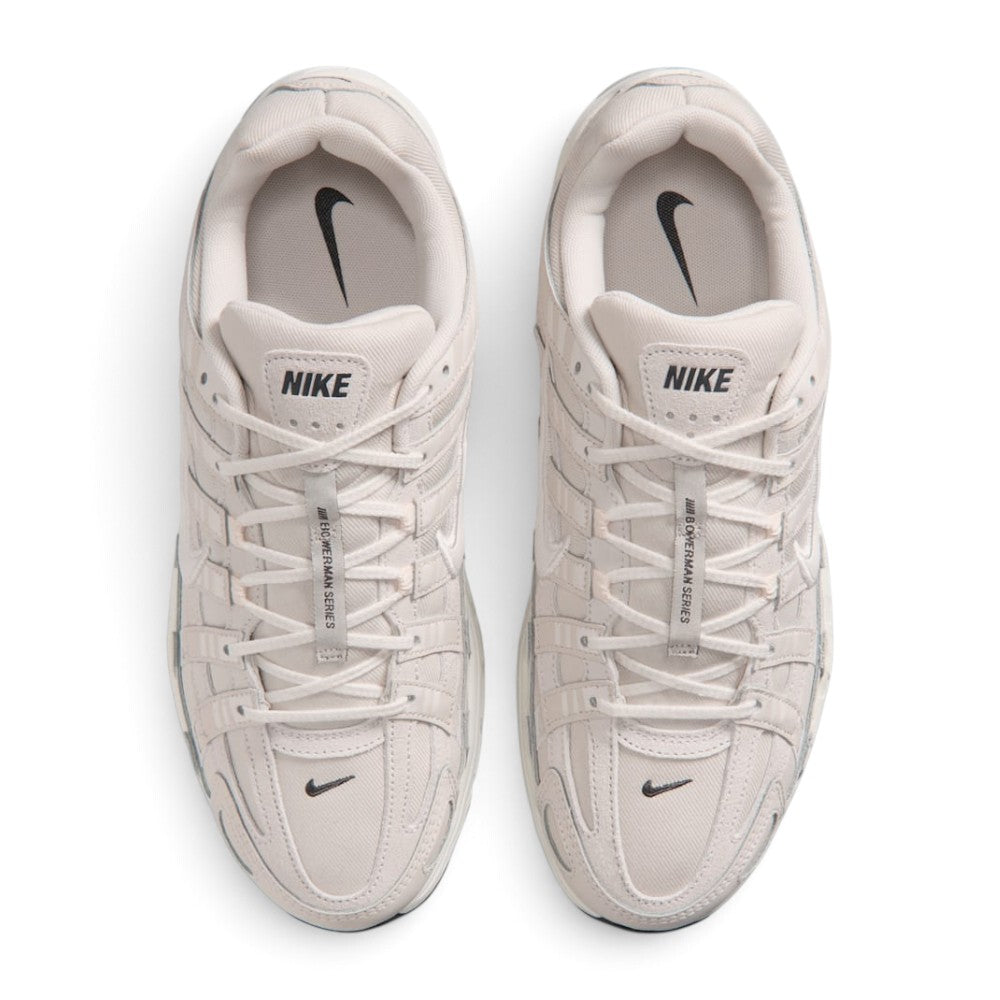 Focuses on the locked-in central lacing layout, displaying flat laces, vertical tongue webbing, padded tongues with Nike logo tabs, cushioned collars, and soft insoles.