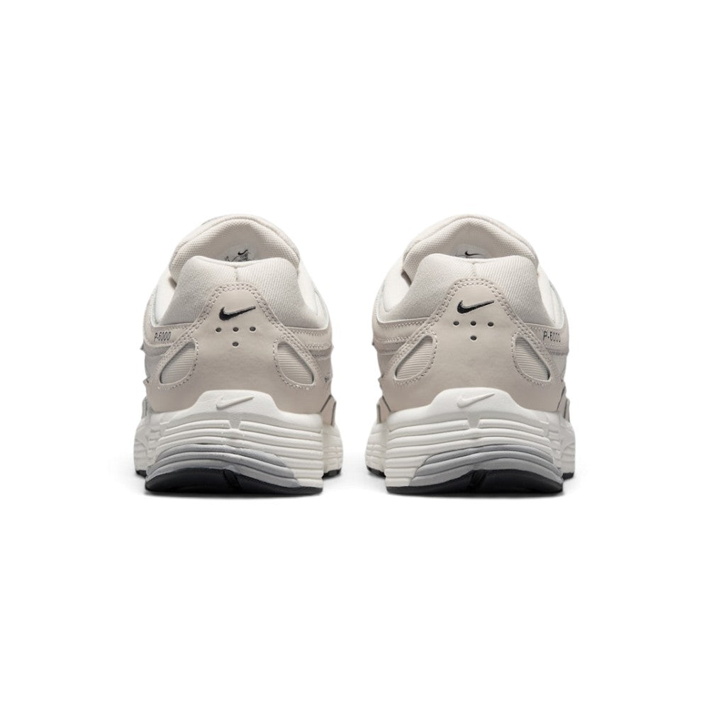 Focuses on the rear profile, displaying the structured synthetic heel counters, micro-Swooshes, ventilation perforations, and the wide base of the ribbed Sail foam midsole.