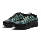 Emphasising the low-slung, technical stance of the trainers and the high-contrast harmony between the deep Mineral Slate mesh, textured black overlays, and bright Steam green lace details.