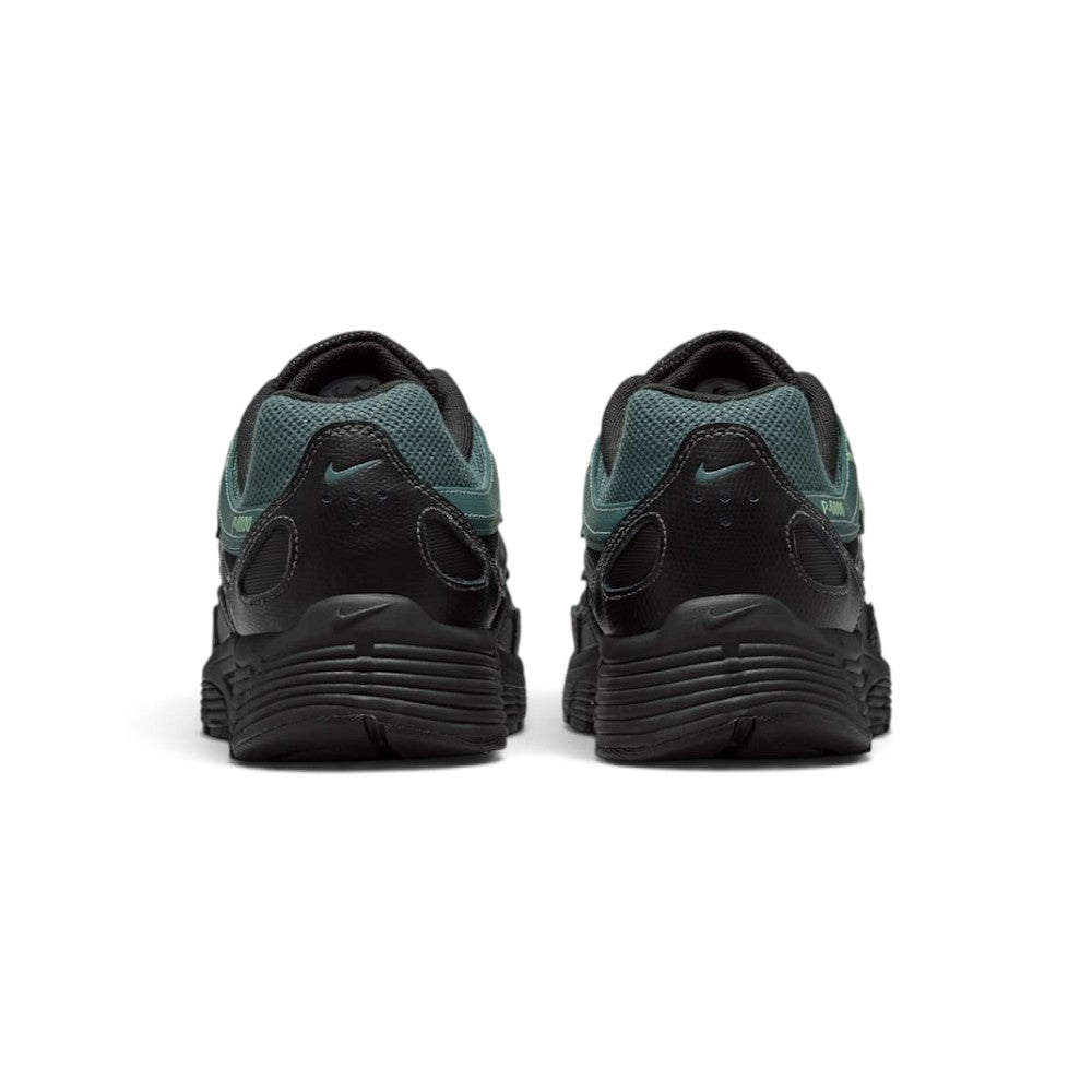 Focuses on the rear profile, displaying the textured black synthetic heel counters, micro Mineral Slate Swooshes, ventilation perforations, and the wide base of the ribbed black foam midsole.