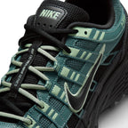Details the micro-precision of the forefoot area, showing the textured Mineral Slate mesh toe box with mini embroidered Swoosh, Steam green eyelet webbing loops, flat laces, and central "Bowerman Series" tongue strip.