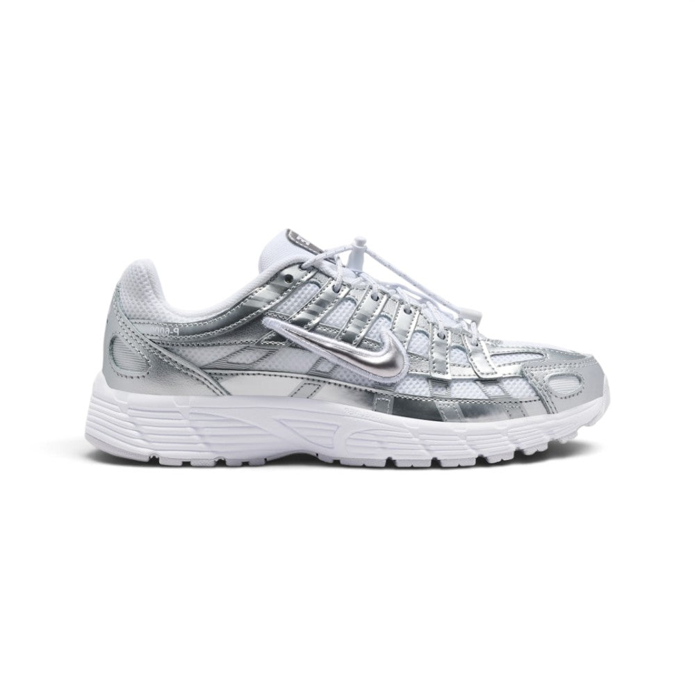 Highlights the early-2000s lateral silhouette featuring gleaming Metallic Silver horizontal and vertical overlays sweeping over white breathable mesh, a white Swoosh with silver outline, toggle lace system, and a grooved white foam sole.