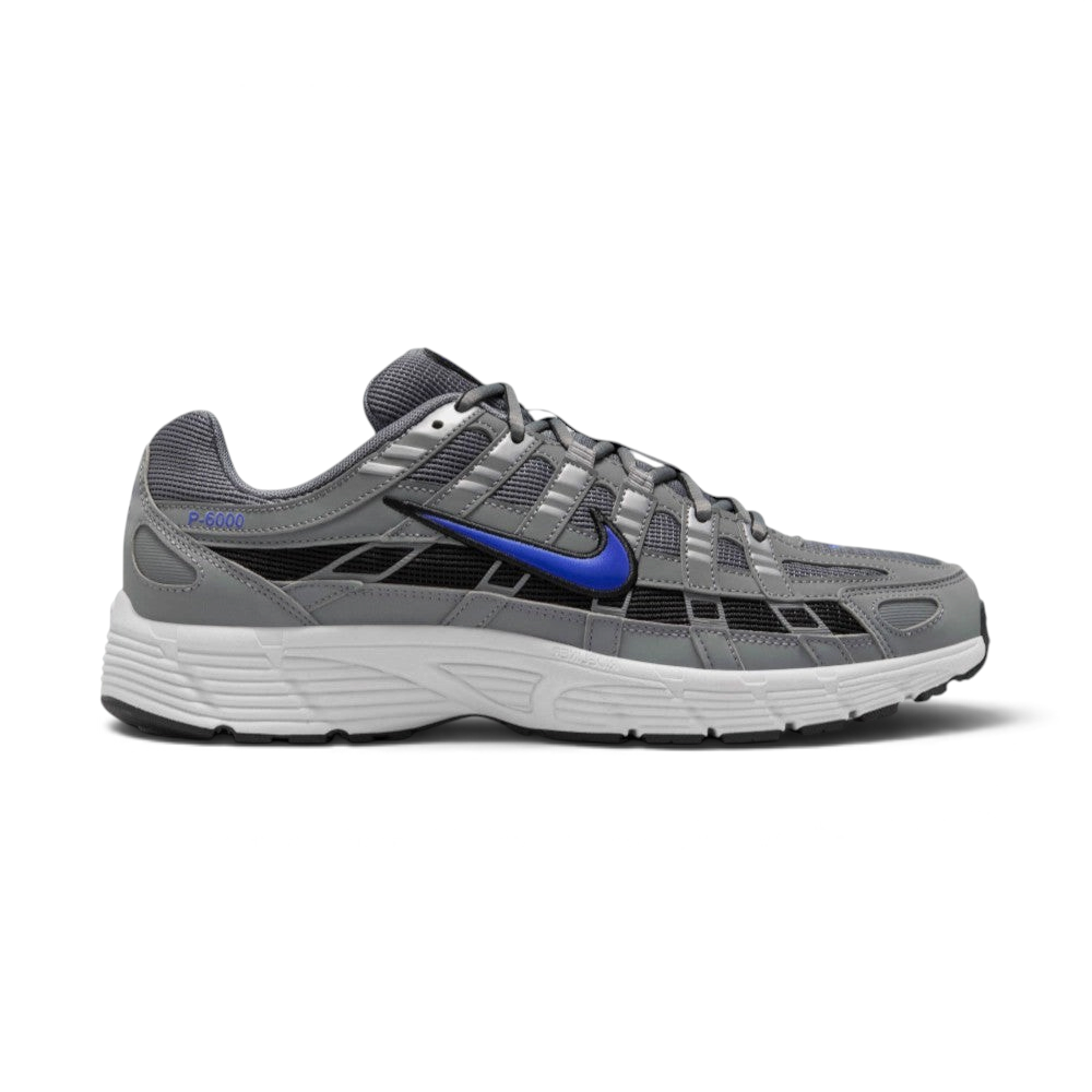 Highlights the lateral profile featuring a bold Racer Blue Nike Swoosh sweeping across the Smoke Grey mesh upper, structured Light Smoke Grey synthetic overlays, dark black underlay panels, and a clean white foam midsole. Main image