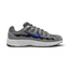 Highlights the lateral profile featuring a bold Racer Blue Nike Swoosh sweeping across the Smoke Grey mesh upper, structured Light Smoke Grey synthetic overlays, dark black underlay panels, and a clean white foam midsole.