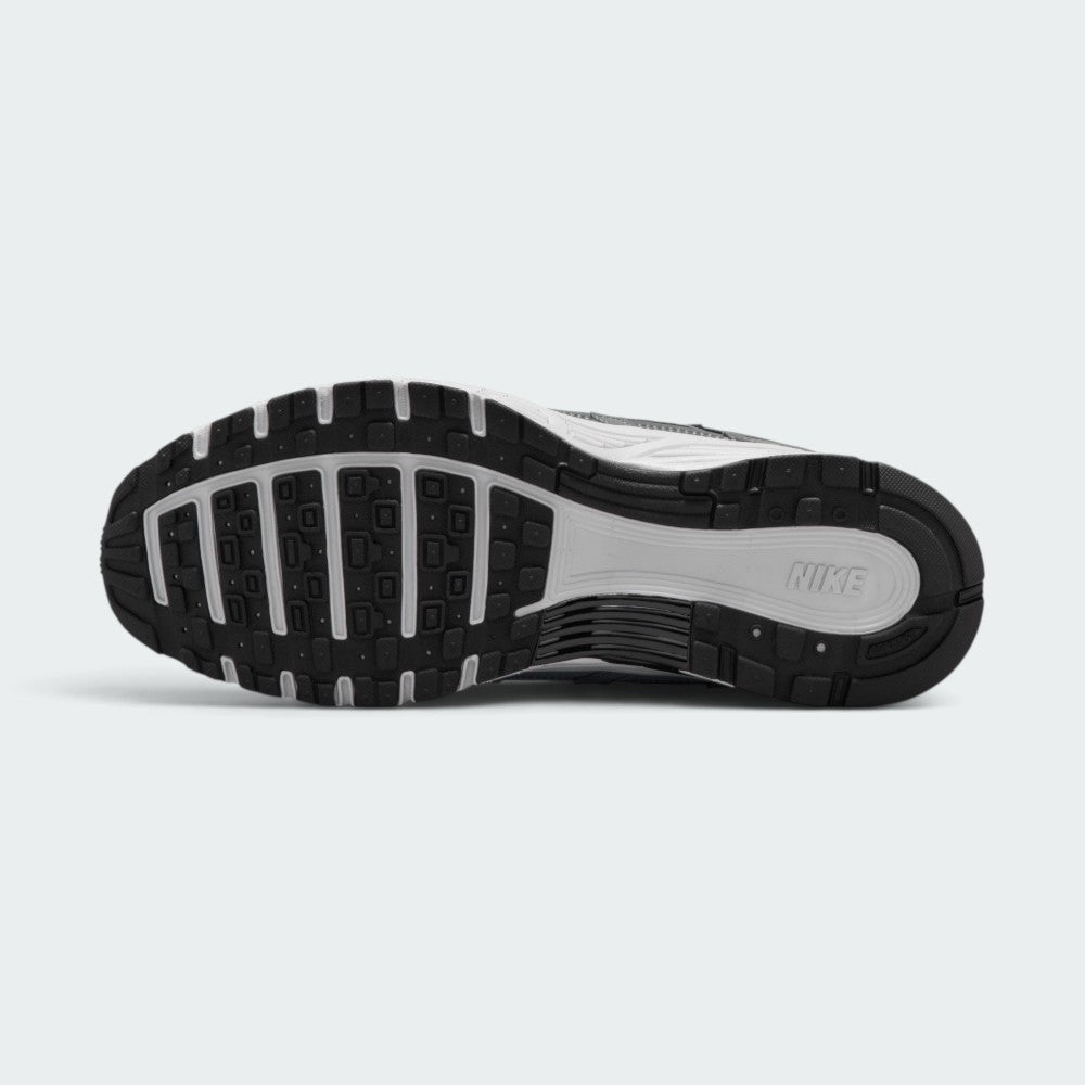 Displays the full-length black and white rubber sole, showcasing the waffle-inspired tread pods and central flex grooves for multi-surface grip.