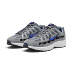 Emphasising the low-cut, athletic 2000s running stance of the trainers and the striking contrast between the neutral grey uppers and electric Racer Blue Swooshes.