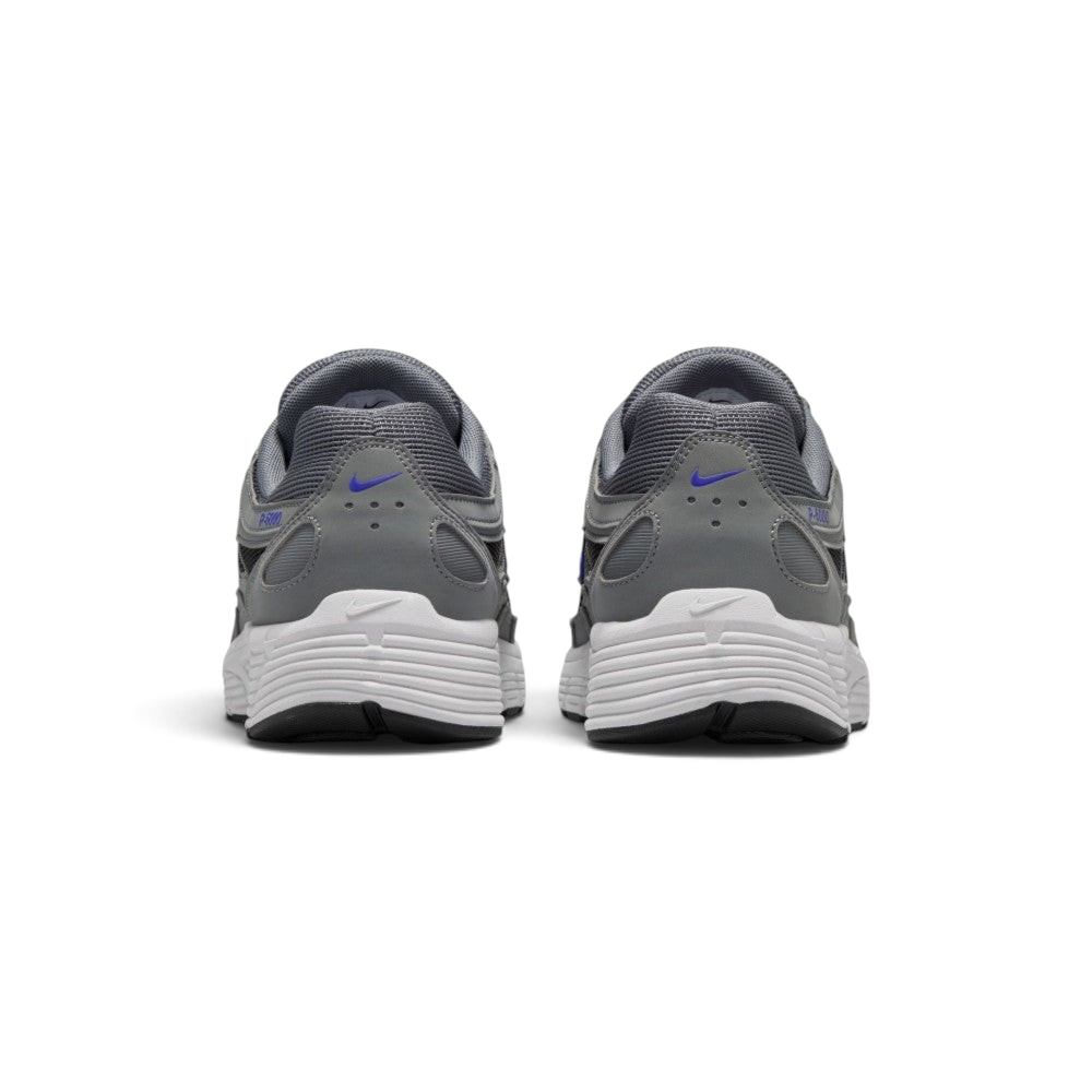 Focuses on the rear profile, highlighting the structured grey synthetic heel counters stamped with Racer Blue micro-Swooshes and blue "P-6000" branding, sitting above the wide white foam midsole base.