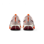 Focuses on the rear profile, highlighting the Hyper Crimson speckled pull loops, circular reflective and orange dots on the heel counters, and the wide footprint of the Sail ReactX midsole base.