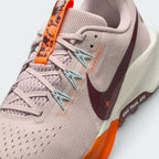 Details the micro-precision of the open-cell forefoot mesh upper, showing the laces, Silt Red suede eyestay overlay, orange floral tongue tab, and pale blue Flywire cables.
