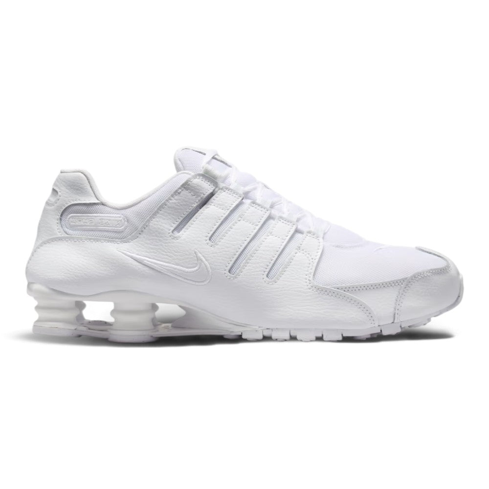 Lateral view showing the streamlined white synthetic leather chassis, tonal micro-perforations, embroidered white mini Swoosh, four independent polyurethane Nike Shox heel columns, sculpted forefoot foam midsole, and white tacky rubber Waffle outsole.