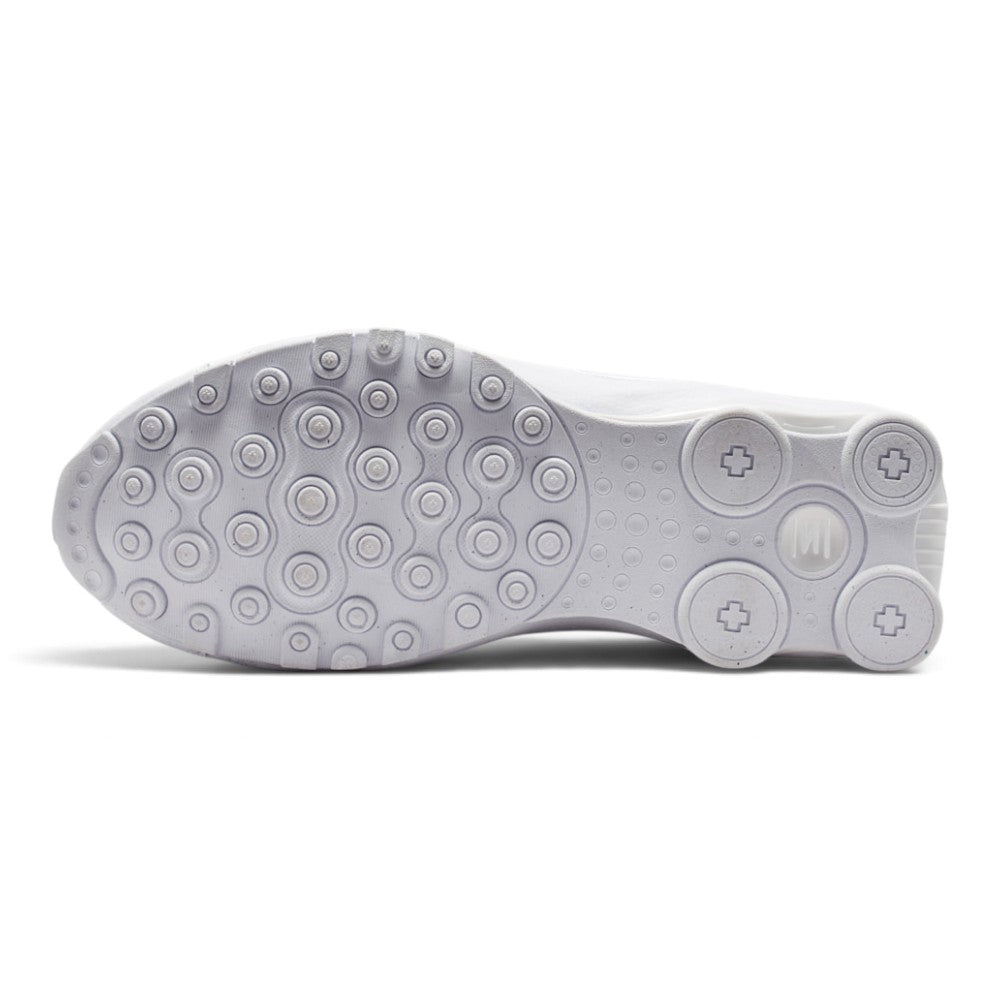 Full-length bottom view displaying the solid white tacky rubber outsole featuring the modified Waffle traction lugs, circular Shox column base plates, flex grooves, and central debossed Nike Shox branding.