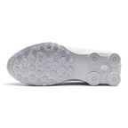 Full-length bottom view displaying the solid white tacky rubber outsole featuring the modified Waffle traction lugs, circular Shox column base plates, flex grooves, and central debossed Nike Shox branding.