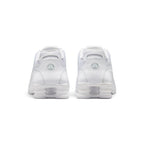 Close-up rear angle focusing on the four white Nike Shox columns between dual transition plates, central heel branding window, reflective accents, and the protective rubber outsole wrap.