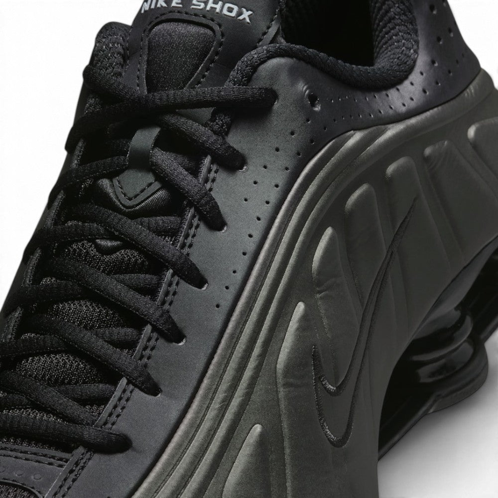 Medial perspective highlighting the inner profile of the shoe, featuring the smooth synthetic quarter, ventilation perforations, clean stitch contours, and bright crimson cushioning pistons.