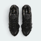 Focuses on the locked-in central lacing layout, displaying the perfect symmetry of the black mesh tongue with "NIKE SHOX" branding, black laces, TPU eyestay overlays, and the RealTree camo print pattern lining the interior collar and footbed.