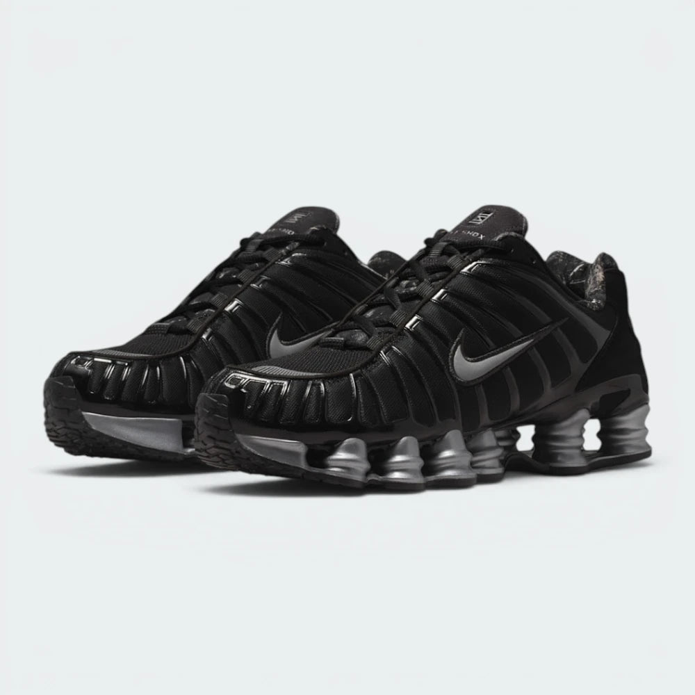 Emphasising the aggressive, forward-leaning mechanical stance of the shoes and the professional contrast between the stealthy black TPU uppers and bright metallic silver Shox pillars.