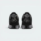 Focuses on the rear profile, highlighting the RealTree camo heel tab stamped with the metallic Shox "S" badge, sitting above the twin Shox heel columns and TPU stability plate.