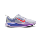 Highlights the lateral silhouette showing the white engineered mesh upper with purple haptic speed lines, raised Hot Lava Nike Swoosh, sculpted Violet Mist and Sapphire blue ReactX foam midsole with debossed "- reactx -" lettering, and black podular rubber outsole.