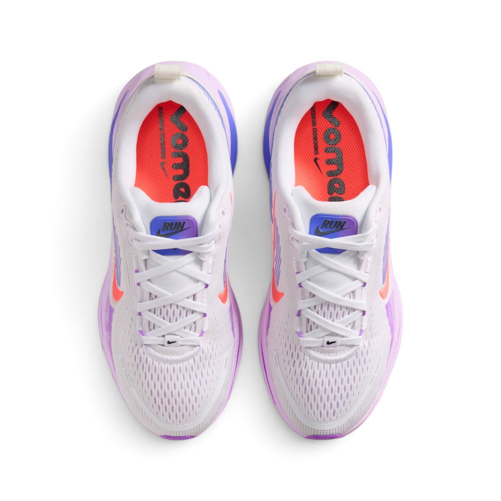 Focuses on the locked-in central lacing layout, displaying the flat white laces, purple-to-blue gradient tongue badges with black "RUN Vomero 18" branding, padded white collars, and bright Hot Lava insoles stamped with bold black "vomero" graphics.