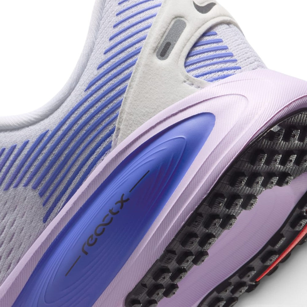 Highlights the "unreal" clean finish of the rear lateral quarter, showing the sculpted lilac foam midsole with the embedded Sapphire blue oval pod debossed with "- reactx -", the nubby black rubber outsole tread, and the reflective heel tab detail.