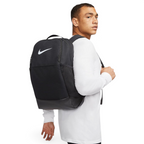 Trade Sports model wearing a black Nike Brasilia 9.5 training backpack with a white Swoosh logo on a white background