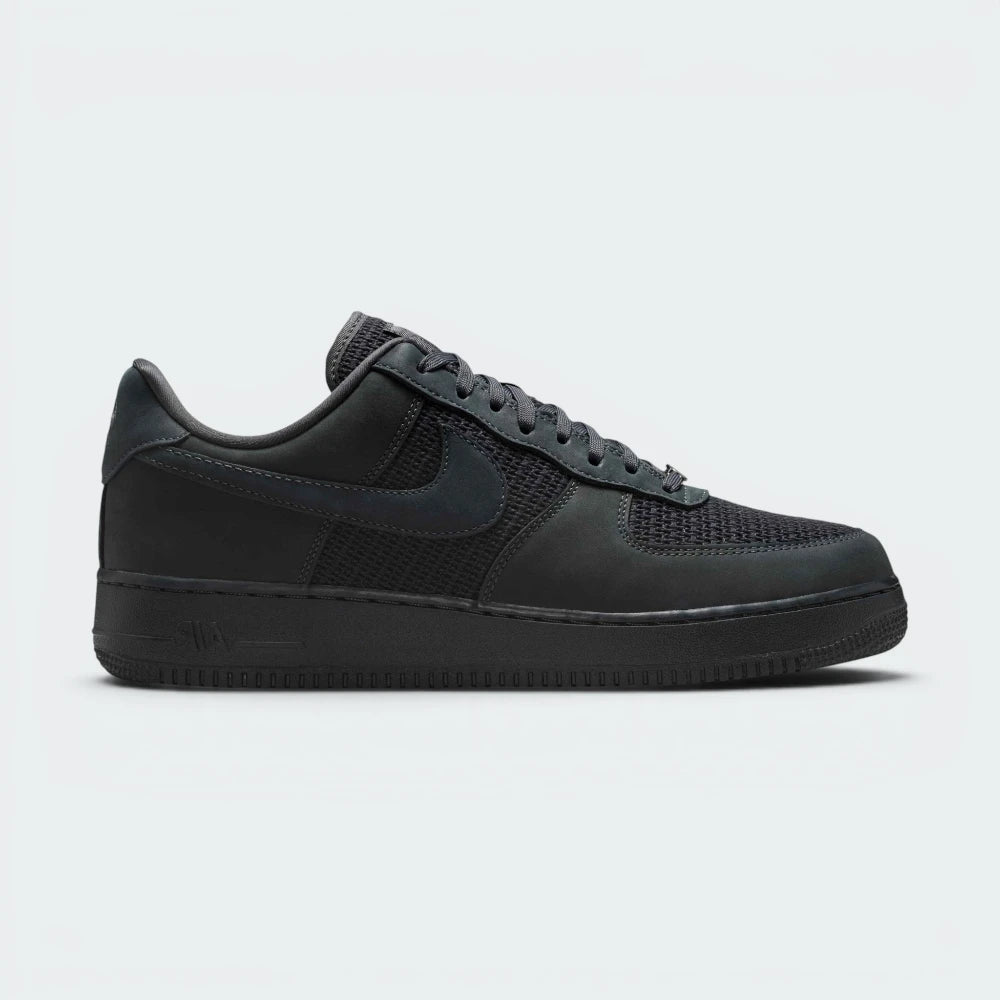 Highlights the high-velocity sweep of the Off-Noir leather Nike Swoosh, showing the professional, multi-textured contrast between the dark Anthracite canvas underlays and the premium leather overlays resting above the solid anthracite midsole wall.