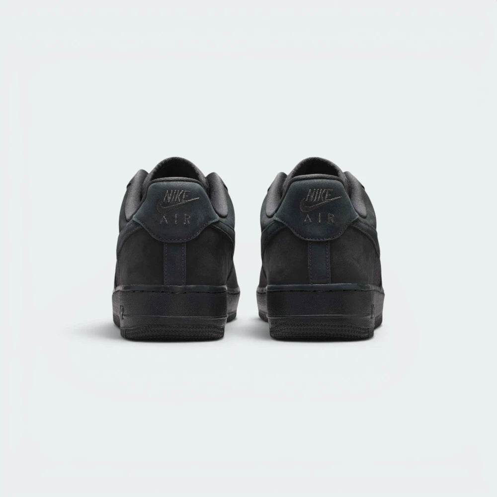 Focuses on the contoured shape of the padded low-cut collar, highlighting the embroidered Nike Air logo on the leather heel tab sitting squarely above the clean midsole line.