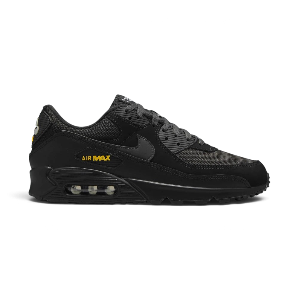 Highlights the high-velocity sweep of the crisp White Nike Swoosh, showing the professional, layered texture of the Black and Anthracite panels resting above the bold University Gold Max Air cassette window frame.
