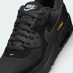 Details the premium mudguard stitching wrapping the front toe cap protection matrix and the clean configuration of the variable lacing eyelets.