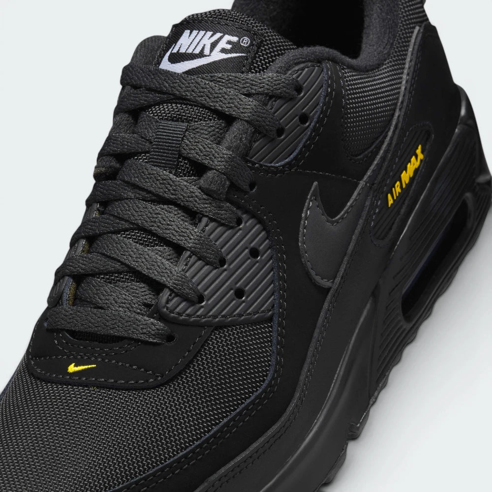 Details the premium mudguard stitching wrapping the front toe cap protection matrix and the clean configuration of the variable lacing eyelets.