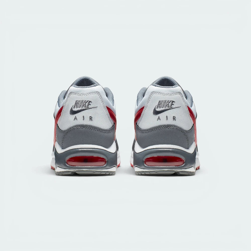 Focuses on the rear profile of both shoes, highlighting the classic grey nubuck-textured heel counters stitched with the Nike Air logo, positioned neatly above the sturdy grey heel frames and the translucent Gym Red Air window.